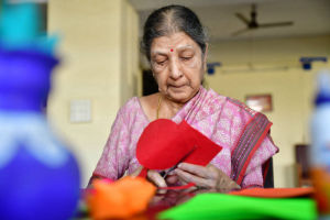 An elderly lady doing some arts and crafts at Nightingales Trust Day Care Centre