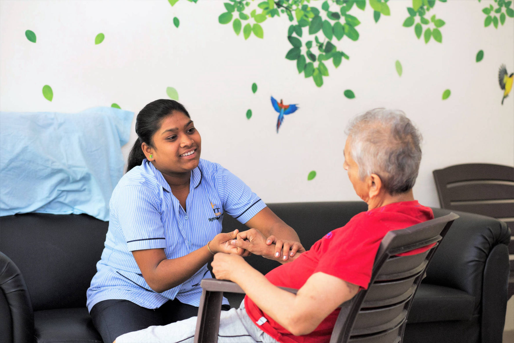 A caregiver at one of NMT's Residential Care Centres shows tender care to a resident